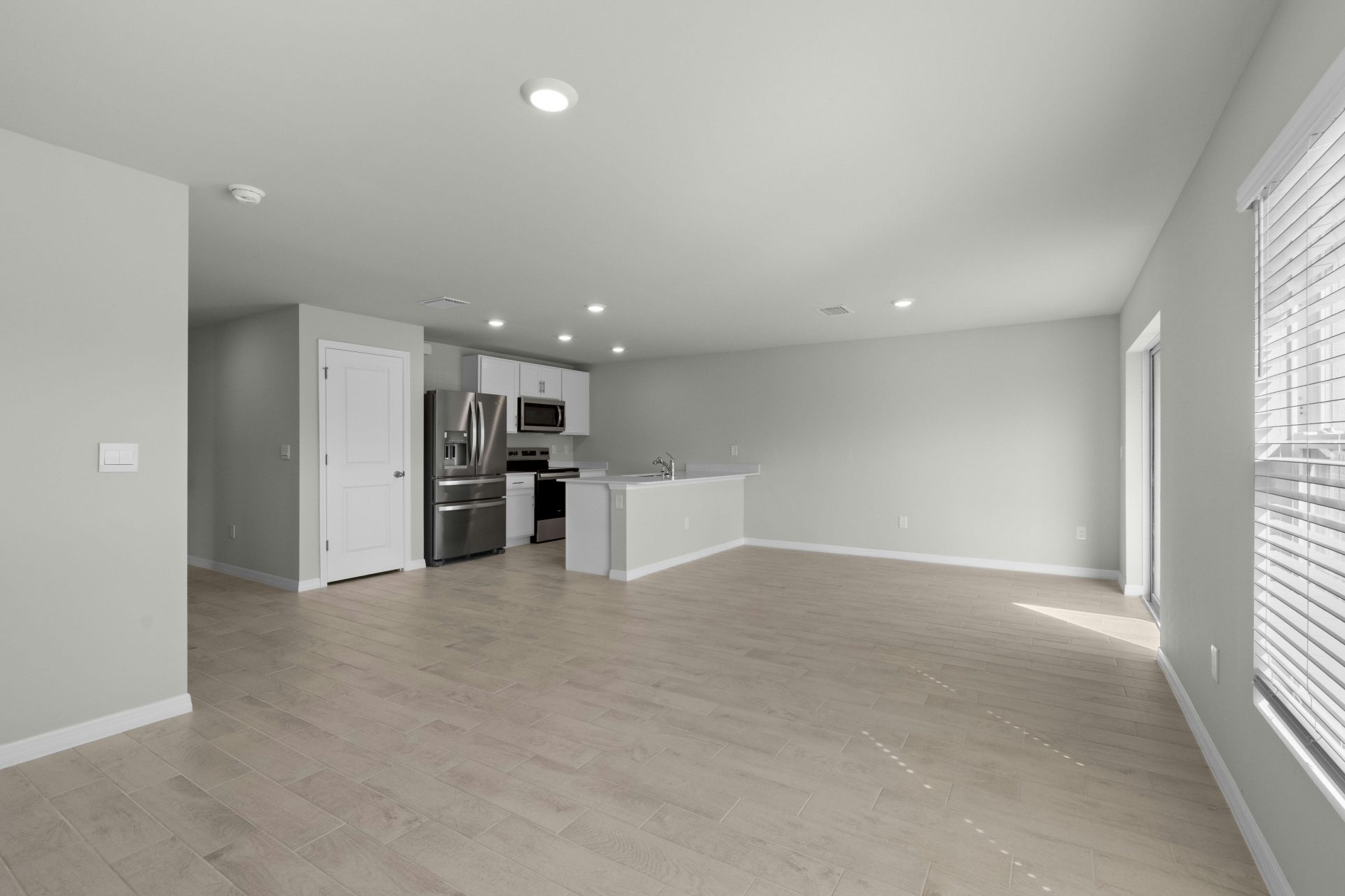 Cocina y sala de estar de concepto abierto, luminosa y espaciosa, con electrodomésticos modernos e iluminación natural.