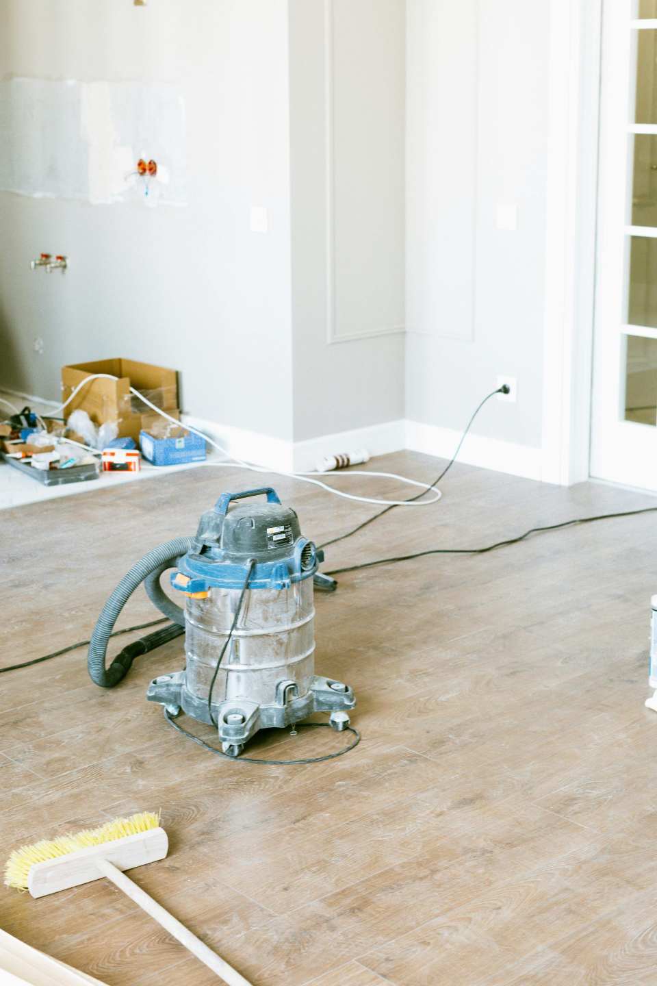 Aspiradora y herramientas en una habitación en proceso de renovación, lo que muestra la mejora del hogar.